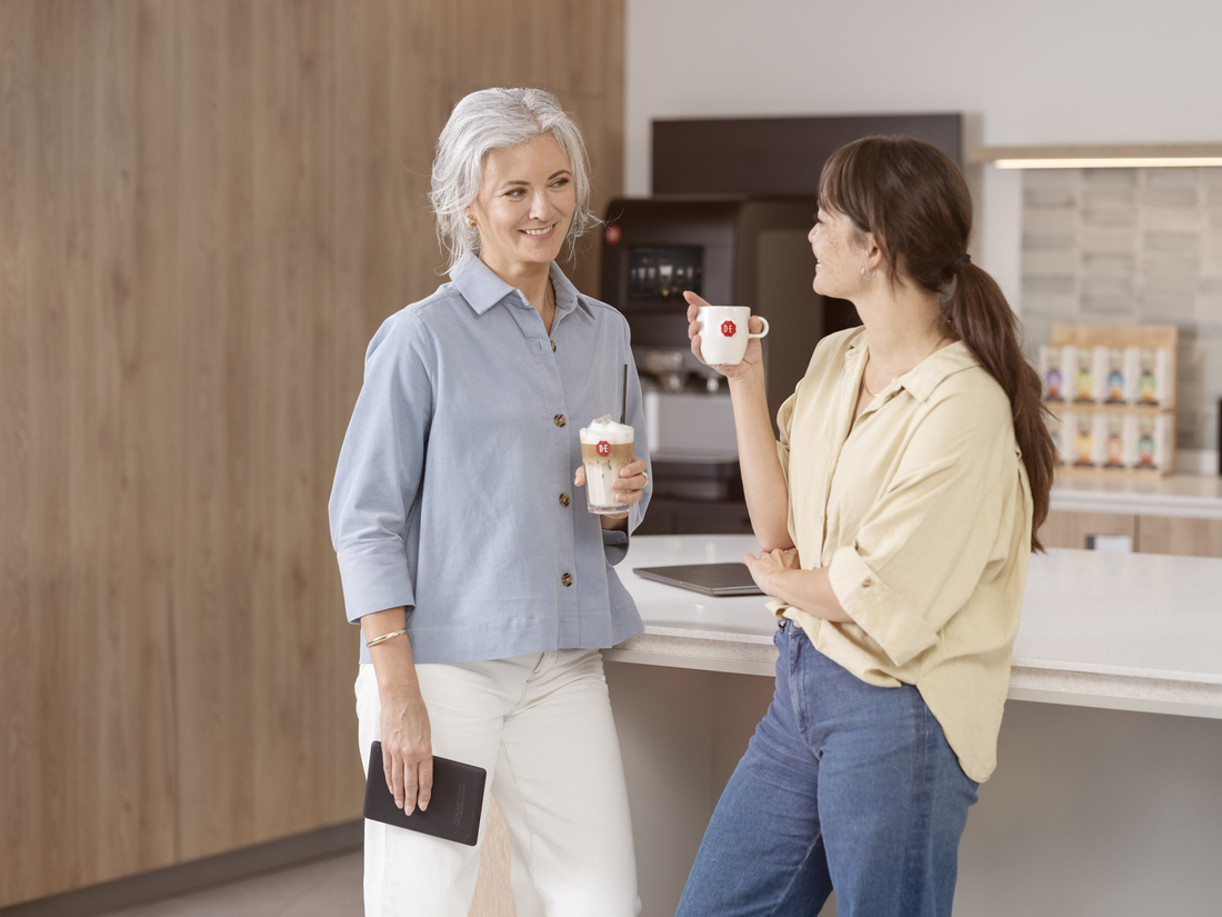Two colleagues catching up with a cup of DE coffee