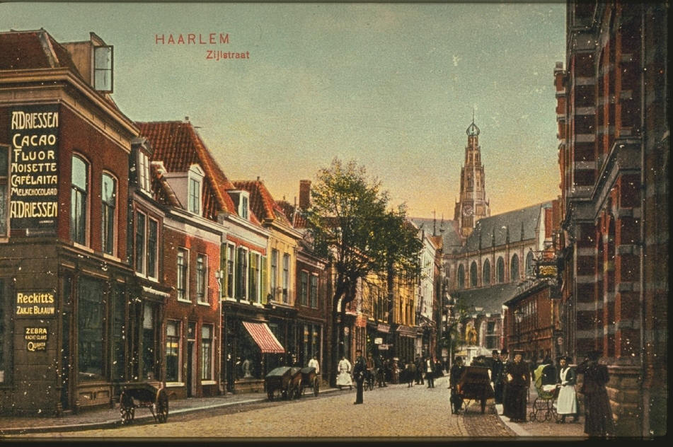 Carte postale ancienne montrant Zijlstraat à Haarlem avec passants, calèches et la tour de la Grote Kerk.